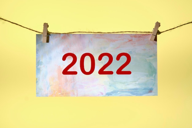 2022 scritte su carta su fondo giallo. Capodanno