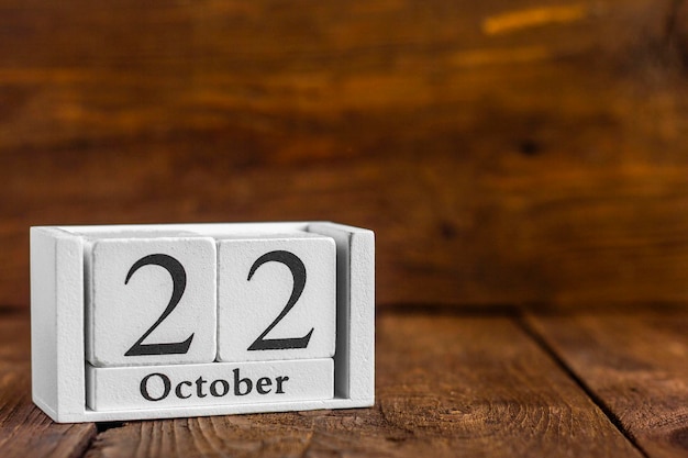 22 ottobre sul calendarioCubetti di legno con data su fondo di legno scuro