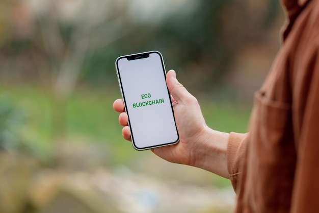 23 nov 2021 - Wroclaw, Polonia: Uomo tiene iPhone con testo verde eco blockchain. Tendenza dell'anno 2022