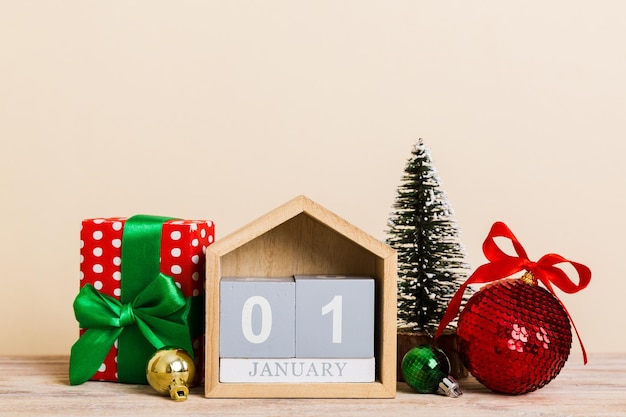 25 dicembre Composizione di Natale su sfondo colorato con un calendario in legno con una confezione regalo giocattoli gingillo spazio copia