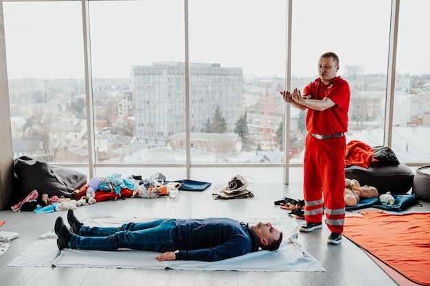 26032022 Kiev Ucraina Persone che imparano a salvaguardare una vita quando una persona è ferita o priva di sensi viene soffocata seduta insieme all'istruttore durante l'addestramento di primo soccorso al chiuso