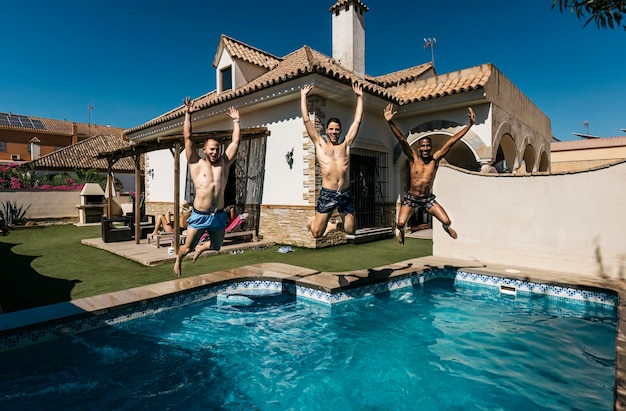 3 amici si tuffano in una piscina in estate