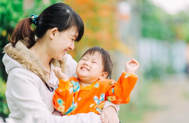 3 anni carino bambino sentirsi felice e sorride con la madre in giardino.