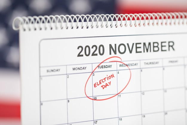 3 novembre 2020 il giorno delle elezioni concetto. Calendario da tavolo con 3 novembre contrassegnato in rosso e bandiera USA sullo sfondo