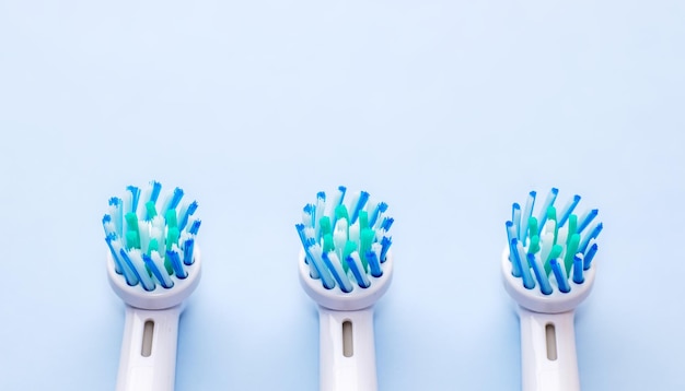 3 pezzi di riserva per testine di spazzolino elettrico su sfondo blu chiaro concetto di cura dentale