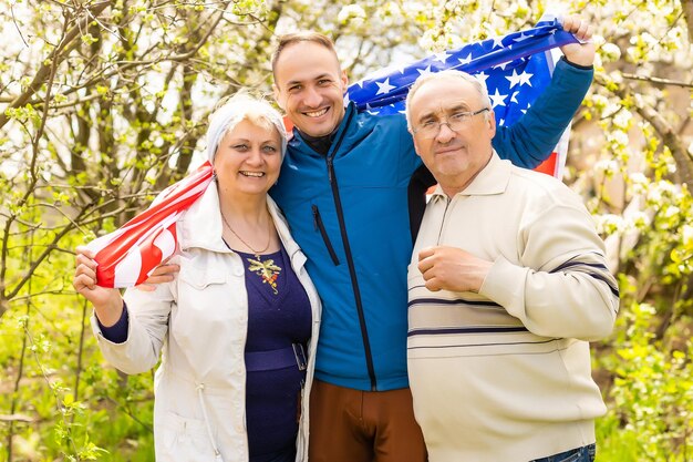 4 luglio: famiglia americana dietro la bandiera degli Stati Uniti.