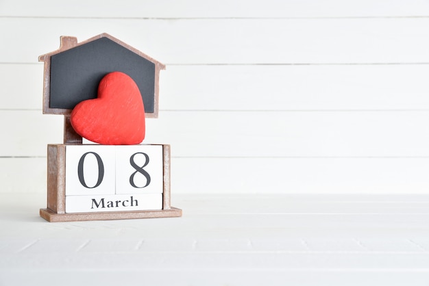 8 marzo calendario di blocco di legno del testo con cuore rosso su fondo di legno bianco.