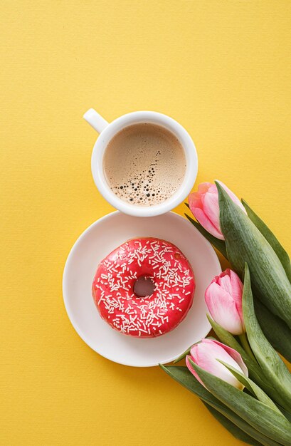 8 marzo Giornata internazionale della donna numero otto composta da una tazza di caffè e una ciambella con guarnizione rosa accanto a tulipani rosa spazio per il testo