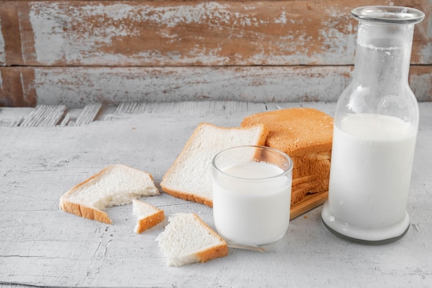 â€‹â€pane a fette con un bicchiere di latte e una bottiglia di latte fresco