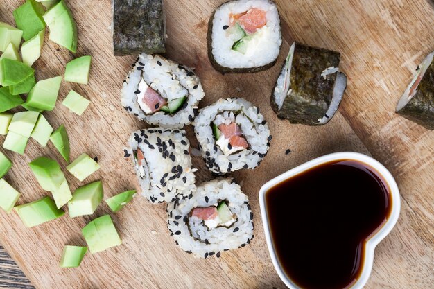 A base di riso e trota o salmone con verdure sushi con salsa di soia, riso asiatico e frutti di mare sul tavolo durante i pasti, cibi asiatici e salsa di soia