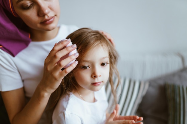 A casa in isolamento la mamma pettina la figlia dopo il sonno