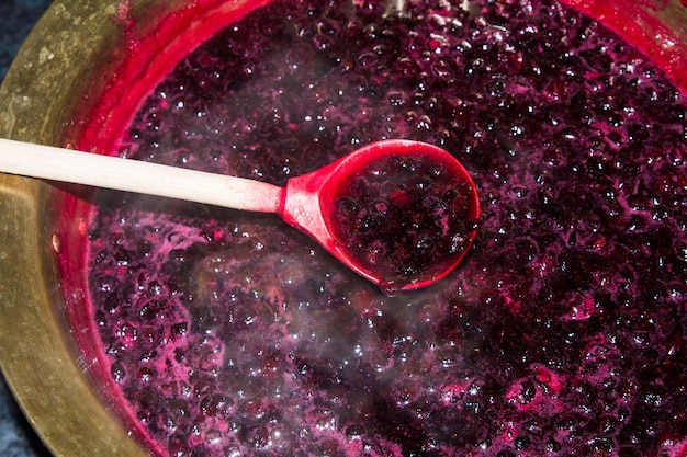 A casa la marmellata di ribes nero viene cotta in una bacinella di rame e mescolata con un cucchiaio di legno