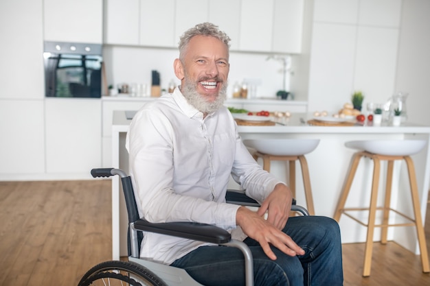 A casa. Uomo disabile maturo dai capelli grigi nella cucina