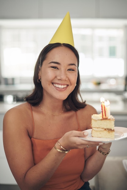 A chi non piace la torta di compleanno Inquadratura di una giovane donna in posa con un pezzo di torta a casa