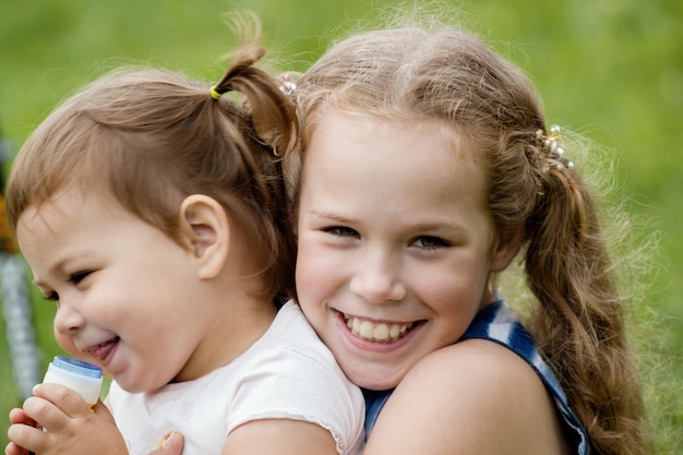 A due sorelline che giocano nel parco, passeggiate all'aperto - concetto di infanzia