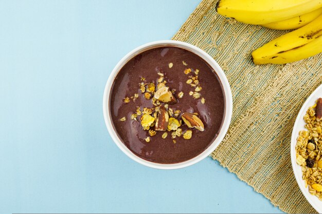 AÃƒÂ§ai brasiliano in una ciotola bianca con banana, muesli e castagne.