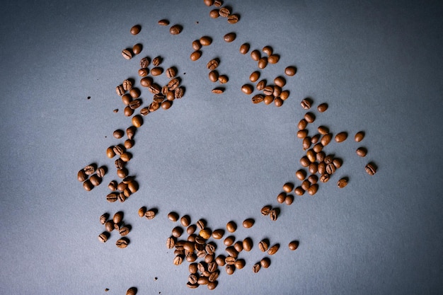 A forma di cuore a base di chicchi di caffè su una superficie di legno