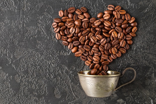 A forma di cuore di chicchi di caffè tostati su sfondo scuro