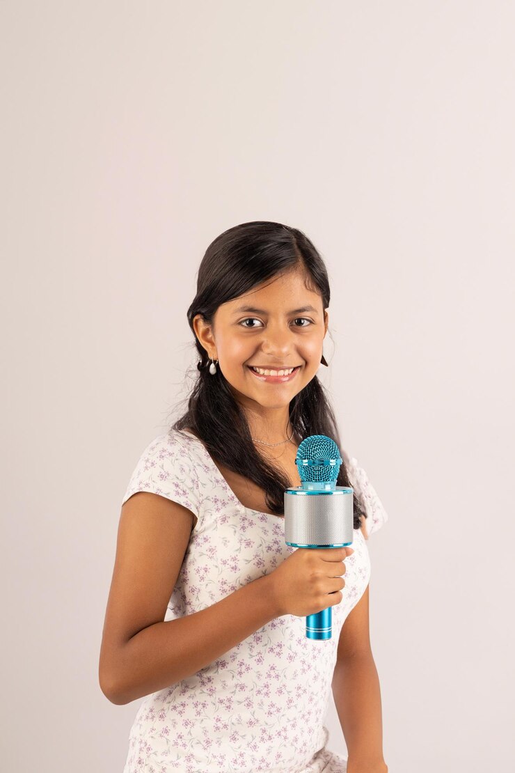 A girl is holding a microphone and smiling