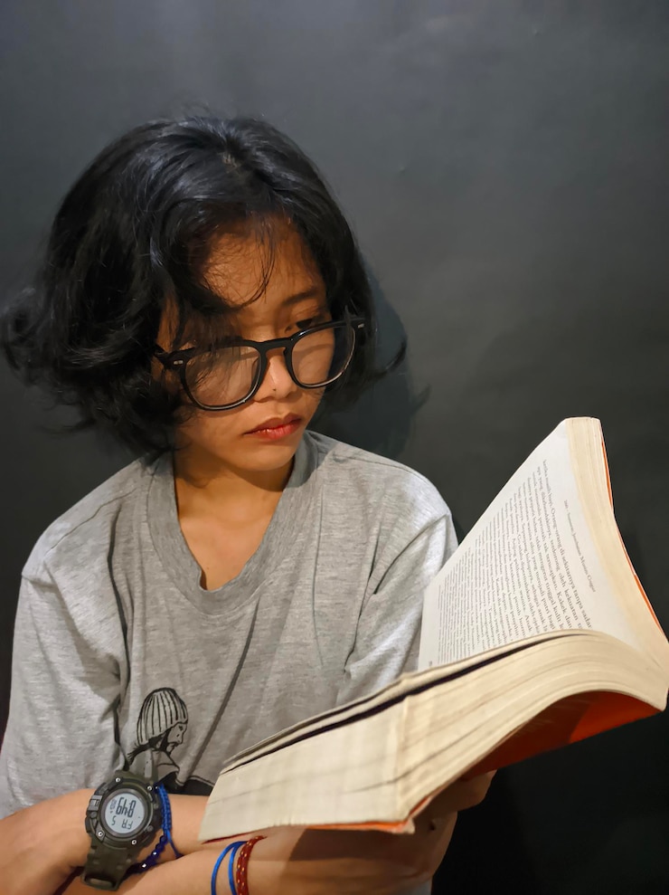 Photo a girl reading a novel with eye glasses on