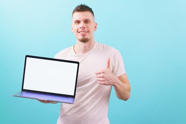 A man holding a laptop with an empty blank screen and shows thumb up on blue Guy Success Business