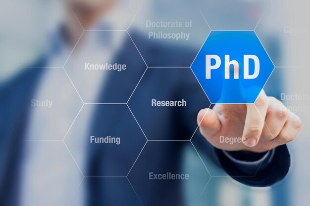 A man is holding a blue button that says phd on it.
