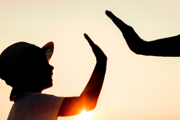 A mani di felice padre e figlio in riva al mare sul viaggio silhouette natura