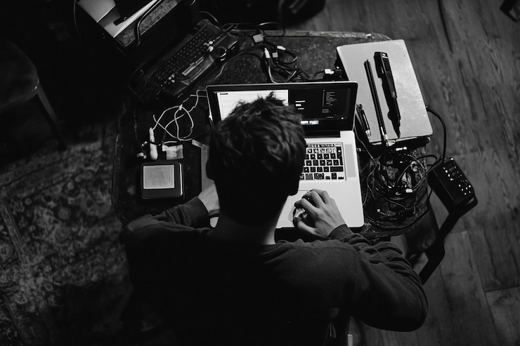 Photo a person is using a laptop with a keyboard and a phone on the table