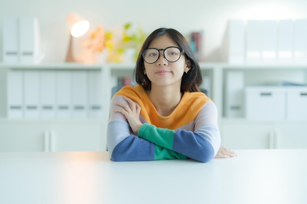 A prendersi una pausa dallo studio in biblioteca c'è una giovane donna sorridente o uno studente che indossa gli occhiali