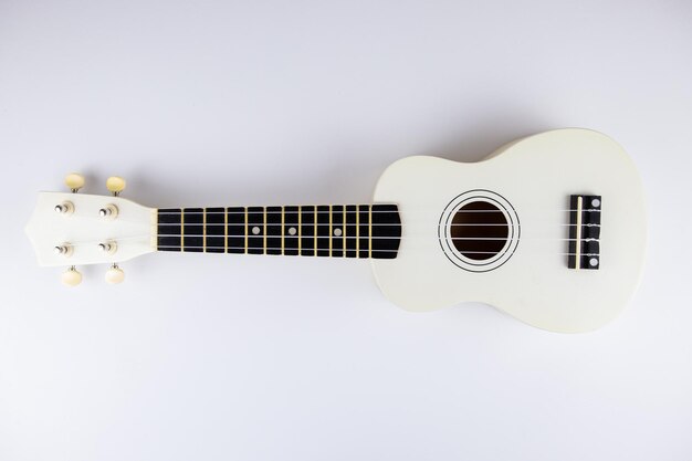 A stringhe di un bel primo piano di chitarra bianca su sfondo bianco ukulele