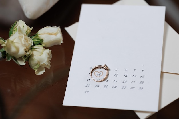 A white card with a ring on it and a calendar underneath