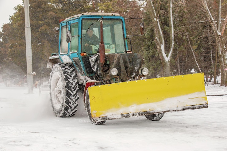 Photo a worker on a tractor removes snow in the city park