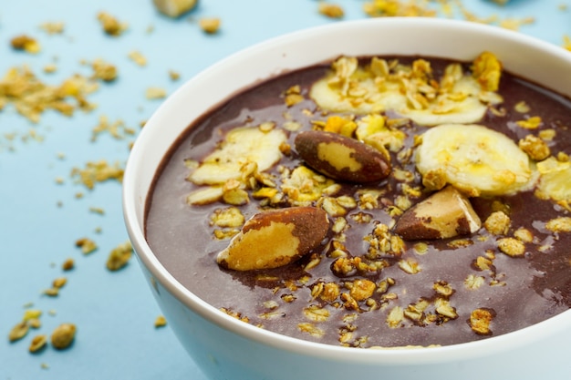 Aai brasiliano in una ciotola bianca con muesli alla banana e castagne Vista dall'alto