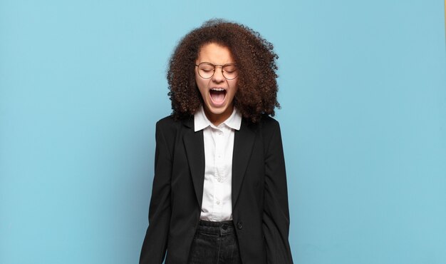 Abbastanza afro adolescente che grida in modo aggressivo, sembra molto arrabbiato, frustrato, indignato o infastidito, urlando no. concetto di business umoristico