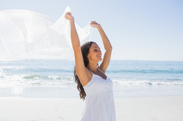 Abbastanza castana in sarong bianchi della tenuta del vestito dal sole