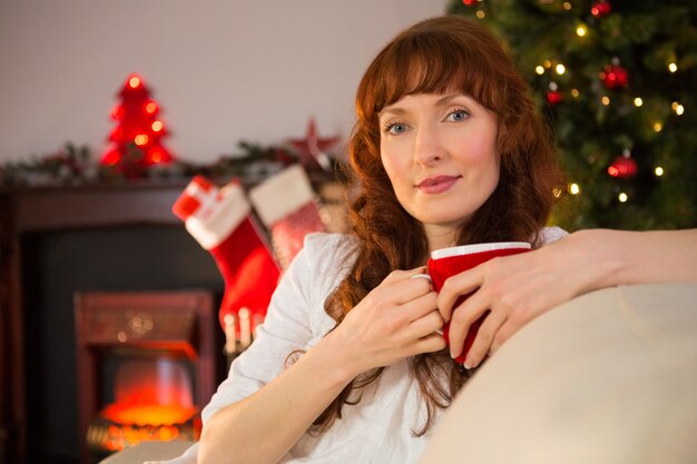 Abbastanza rossa che tiene una tazza di cioccolata calda a natale