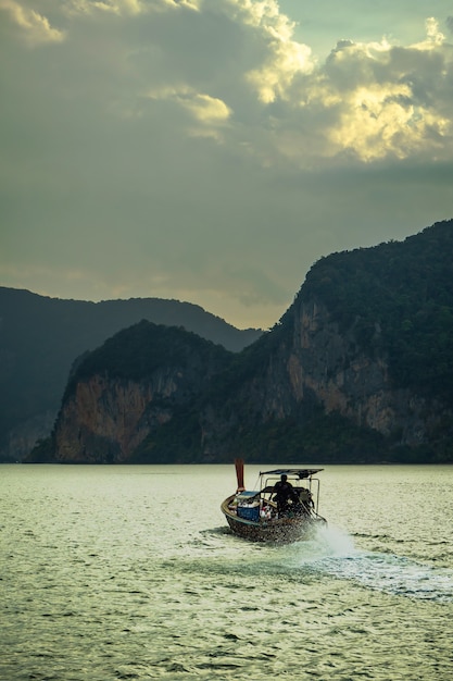 Abbellisca il cielo con i piccoli pescherecci in Tailandia