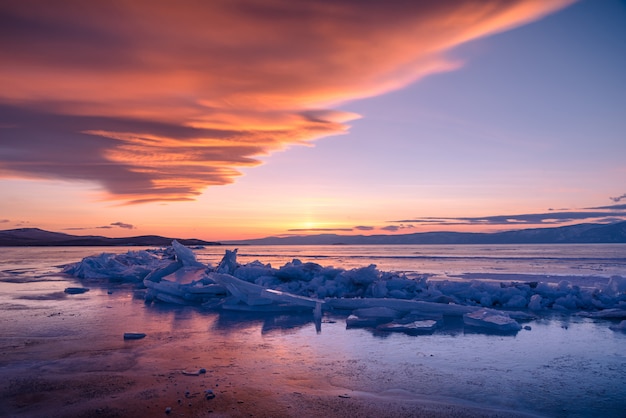 Abbellisca l&#39;immagine del ghiaccio di rottura naturale sopra acqua congelata al tramonto drammatico sul lago Baikal, Siberia, Russia.