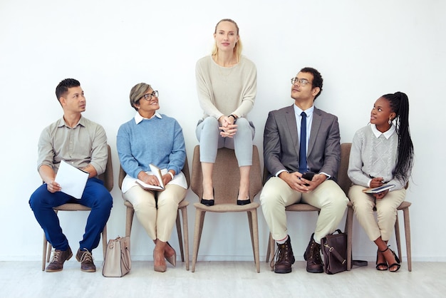 Abbiamo alcune proposte per te Scatto di un gruppo di persone in attesa di essere intervistato per un lavoro in un ufficio moderno