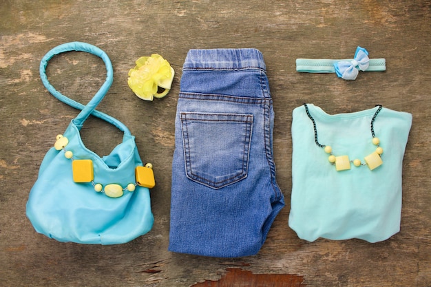 Abbigliamento estivo per bambini: t-shirt, jeans, borsa, perline.