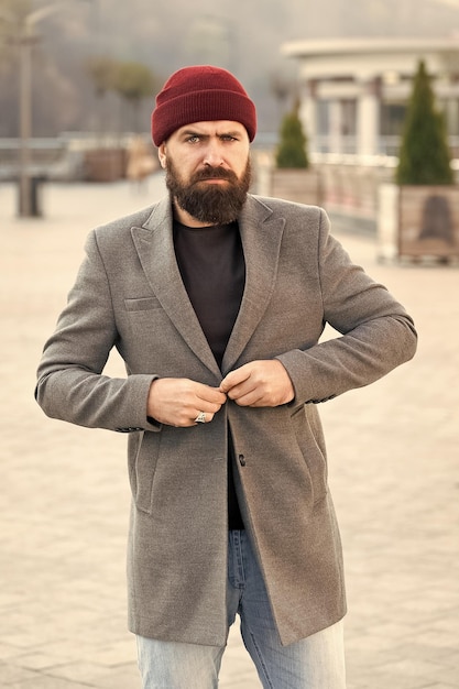 Abbottonare la giacca Abito hipster e accessorio cappello Elegante abbigliamento casual stagione primaverile Abbigliamento uomo e concetto di moda maschile Uomo hipster con barba, cappotto alla moda e cappello alla moda Abito comodo