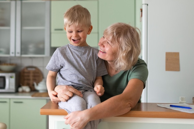 Abbracci della nonna della famiglia felice con il nipote a casa