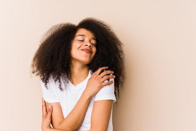 Abbracci di giovane donna afro-americana, sorridente spensierato e felice.