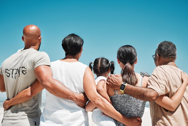 Abbraccia il sostegno e la grande famiglia in spiaggia per i viaggi di vacanza e rilassati al mare a Bali con il cielo blu insieme in estate Ritorno dei genitori ragazza e nonni in vacanza per la pace e la calma