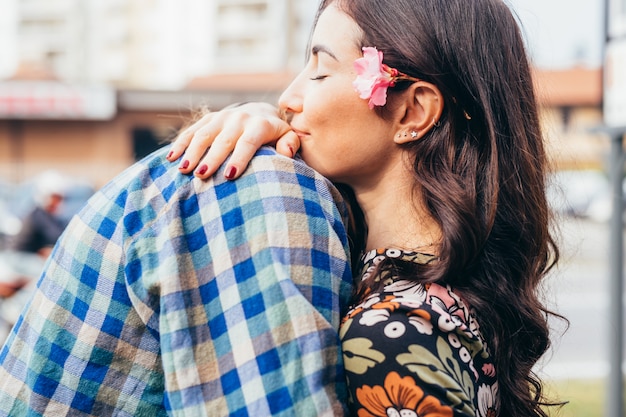 Abbracciare all'aperto delle giovani belle coppie felici