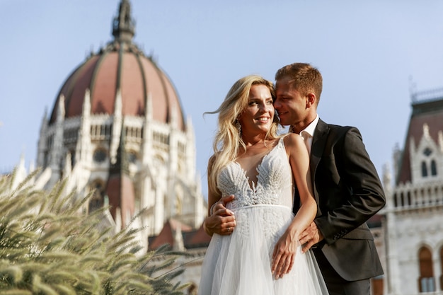 Abbracciare dello sposo e della sposa nella vecchia via della città. Sposi innamorati. Abito di strass di lusso.