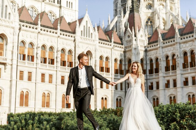 Abbracciare dello sposo e della sposa nella vecchia via della città. Sposi innamorati. Abito di strass di lusso.