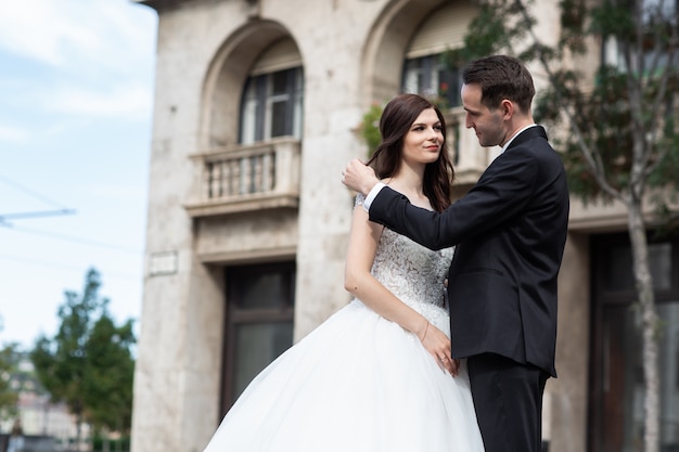 Abbracciare dello sposo e della sposa nella vecchia via della città.