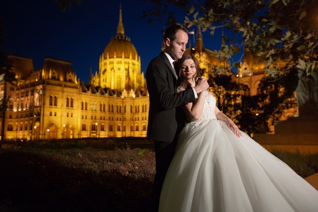 Abbracciare dello sposo e della sposa nella vecchia via della città.