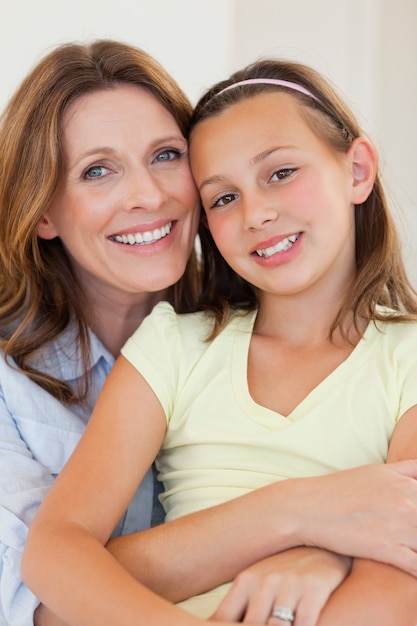 Abbracciare sorridente della madre e della figlia